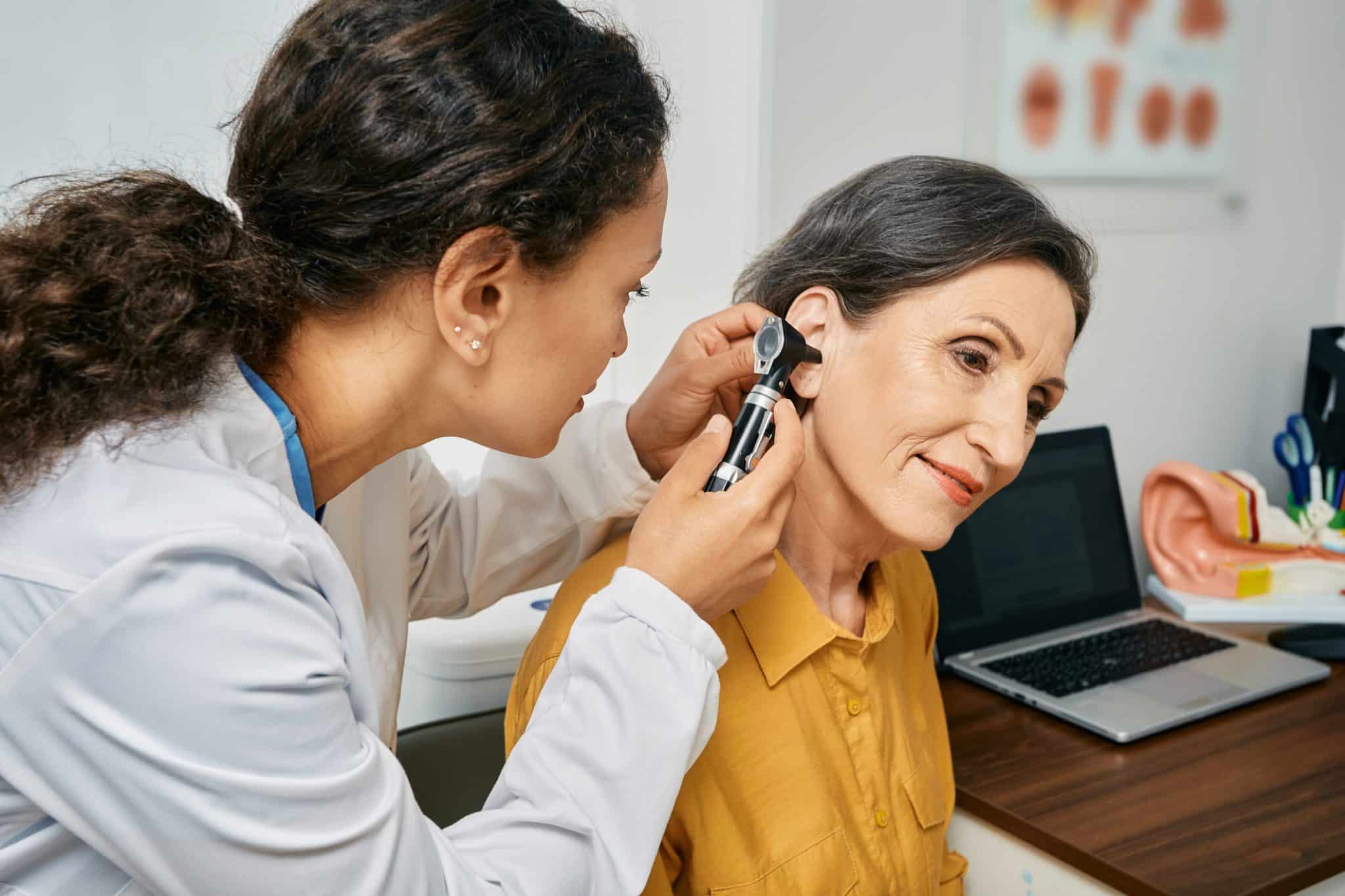 woman-ear-exam-hearing-loss Woman receiving an ear exam to check for hearing loss.