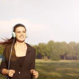 Woman jogging outside while wearing headphones.