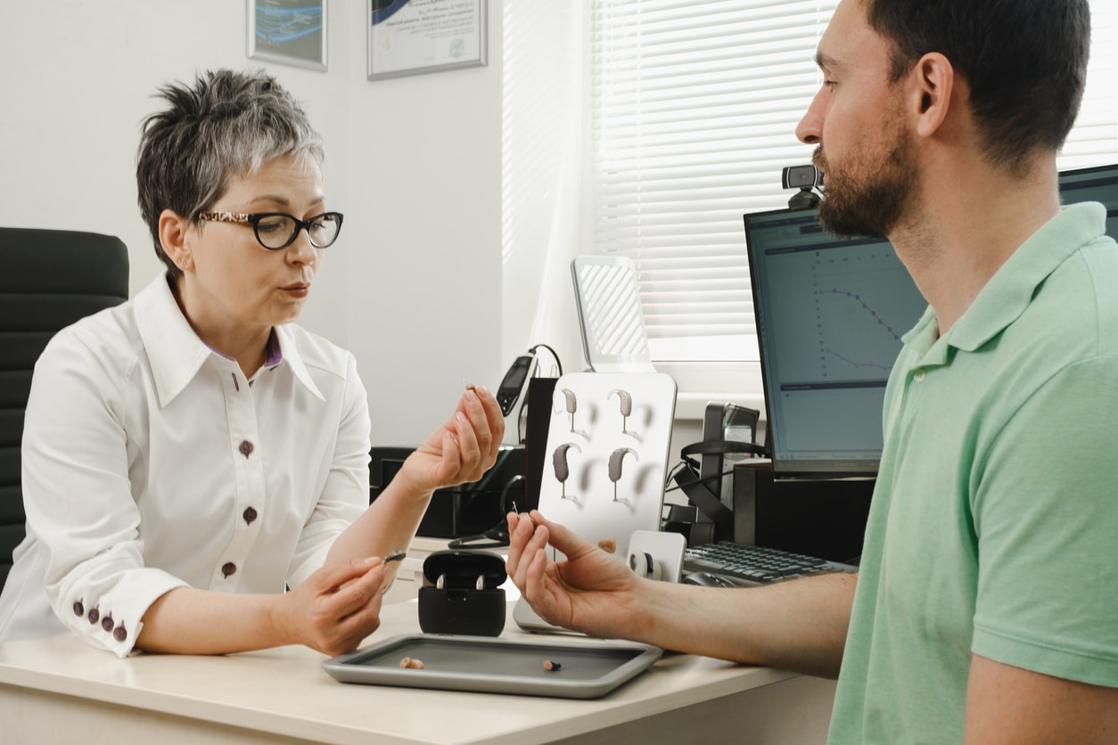 Man talking about hearing aid fitting options.
