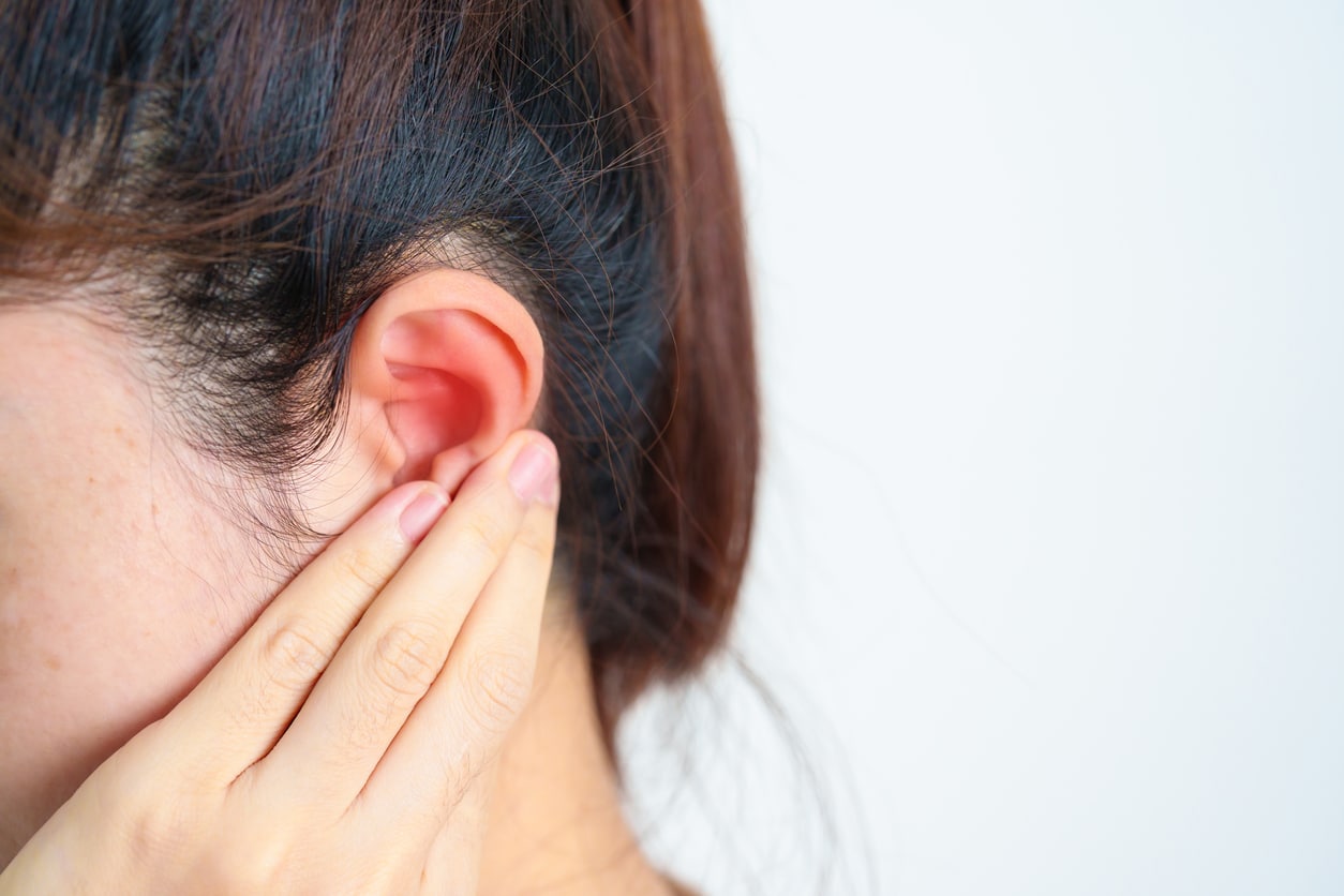 Woman holds hand behind one ear