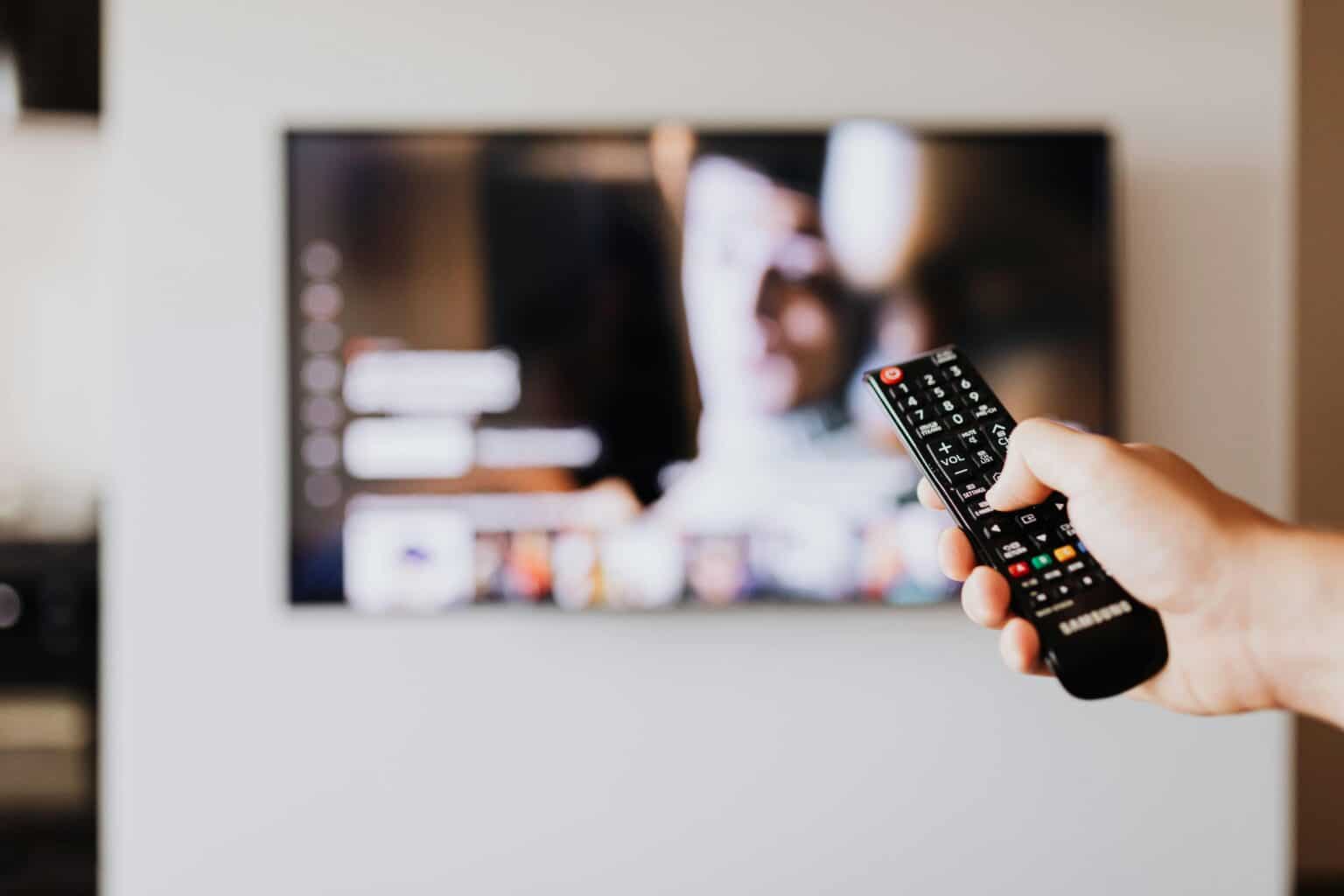 A remote held up in front of a television