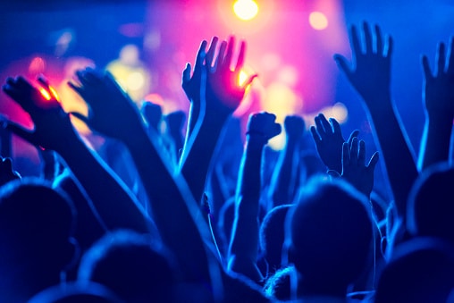 Cheering crowd at a concert. Live music events can pose a major hazard for sound exposure that can damage hearing.